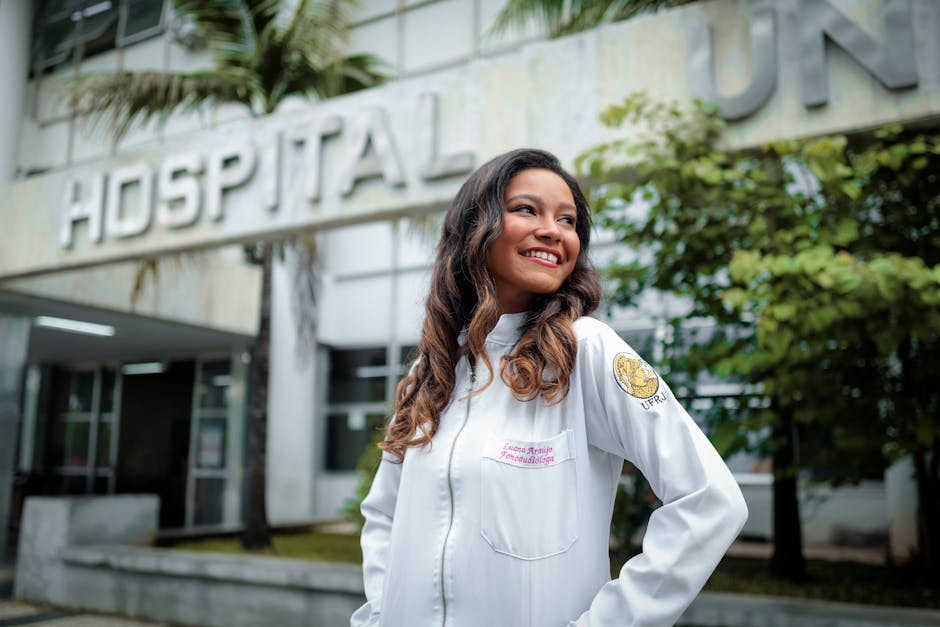 Smiling female doctor standing confidently outside a hospital building.
