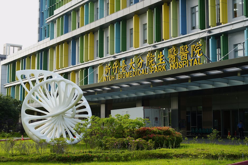Entrance to NTUH Biomedical Park Hospital with modern sculpture and colorful facade in Taiwan.